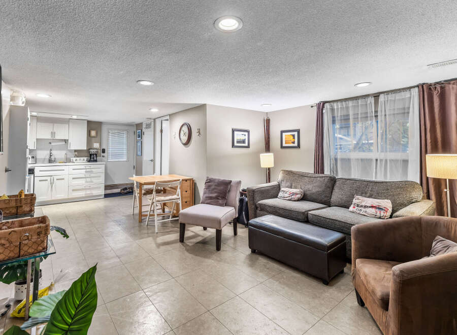 Discover comfortable living in this versatile space, featuring a well-equipped kitchen with white cabinetry and a cozy seating area perfect for relaxation.