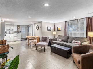 Discover comfortable living in this versatile space, featuring a well-equipped kitchen with white cabinetry and a cozy seating area perfect for relaxation.