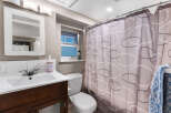 This charming bathroom features a clean white vanity with a modern chrome faucet, complemented by a matching toilet.