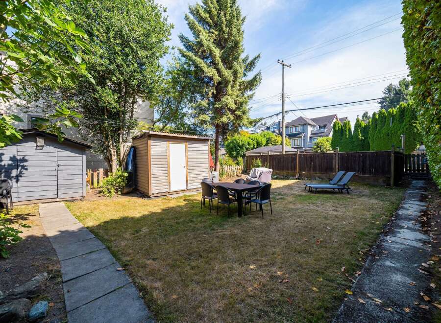 Enjoy outdoor living in this spacious backyard featuring a dining set perfect for al fresco meals and two lounge chairs for ultimate relaxation.