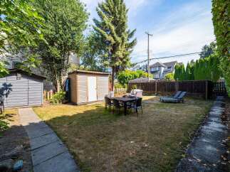 Enjoy outdoor living in this spacious backyard featuring a dining set perfect for al fresco meals and two lounge chairs for ultimate relaxation.