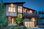 Experience modern mountain living in this stunning architectural home, featuring a striking blend of natural wood and dark corrugated metal siding.