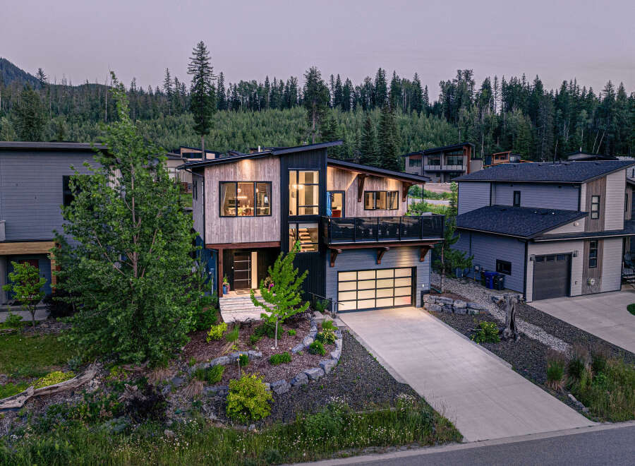 Discover modern mountain living in this stunning contemporary home, featuring a striking architectural design with natural wood and dark siding accents.