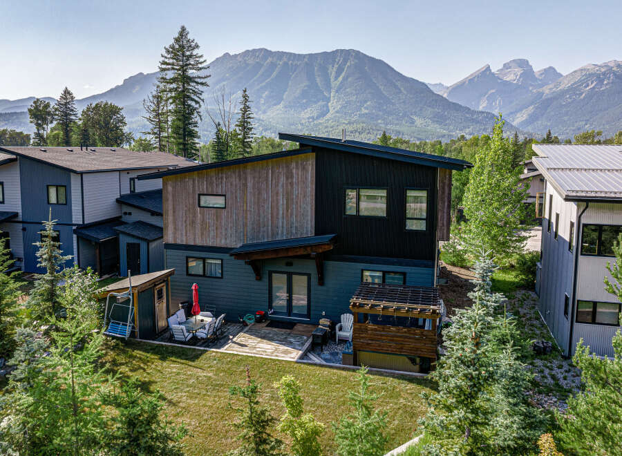Experience modern mountain living in this stunning home, featuring a unique architectural design with wood and dark siding accents.