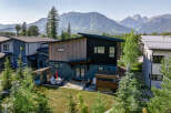 Experience modern mountain living in this stunning home, featuring a unique architectural design with wood and dark siding accents.