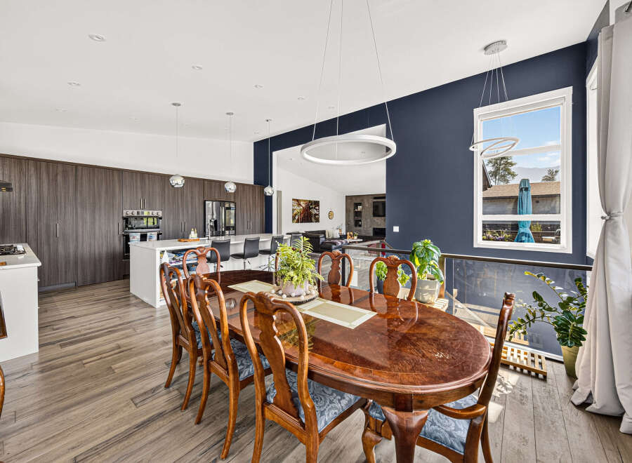 Experience elegant dining in this spacious home, featuring a large, polished wood dining table with ornate chairs perfect for hosting gatherings.