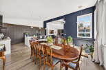 Experience elegant dining in this spacious home, featuring a large, polished wood dining table with ornate chairs perfect for hosting gatherings.