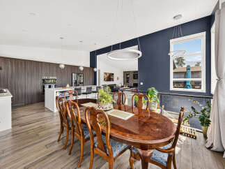 Experience elegant dining in this spacious home, featuring a large, polished wood dining table with ornate chairs perfect for hosting gatherings.