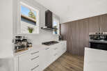 Experience modern kitchen luxury with sleek white cabinetry, a marble countertop, and a professional-grade gas range.