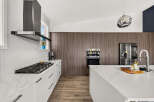 Experience modern luxury in this stunning kitchen, featuring sleek white cabinetry and a marble-patterned countertop.