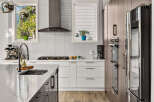 Experience modern luxury in this stunning kitchen, featuring sleek white cabinetry, a sophisticated gas range, and a high-end espresso machine.
