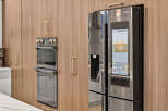 Experience modern luxury in this kitchen, featuring sleek, integrated appliances and warm wood cabinetry.