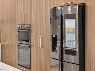 Experience modern luxury in this kitchen, featuring sleek, integrated appliances and warm wood cabinetry.