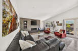 Experience modern living in this spacious living room, featuring a sleek entertainment center with a fireplace and a large sectional sofa perfect for gatherings.