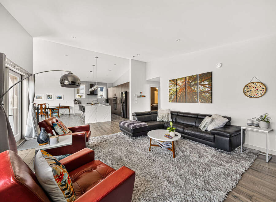 Experience modern living in this spacious open-concept home, featuring a sleek kitchen with a large island and a comfortable living area perfect for entertaining.