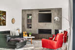 Experience modern living in this stylish living room, featuring a sleek concrete accent wall with a built-in fireplace and entertainment center.