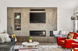 Experience modern living in this stylish living room featuring a sleek concrete accent wall with built-in shelving and a contemporary fireplace.