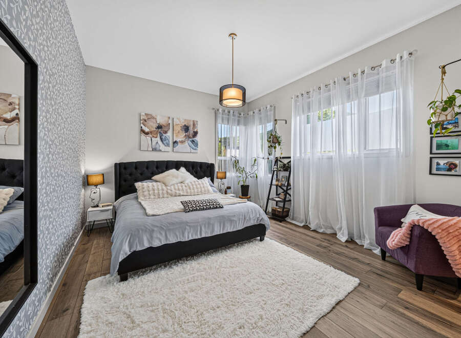 Experience comfort and style in this beautifully appointed bedroom, featuring a plush king-sized bed adorned with soft linens and decorative pillows.