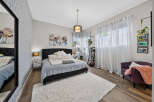 Experience comfort and style in this beautifully appointed bedroom, featuring a plush king-sized bed adorned with soft linens and decorative pillows.