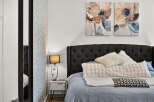 Experience modern comfort in this beautifully appointed bedroom, featuring a plush, tufted headboard and luxurious bedding.