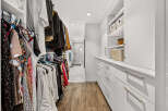 Step into this spacious walk-in closet, featuring ample hanging space for your wardrobe and built-in shelving for organized storage.