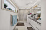 Experience modern luxury in this stunning bathroom, featuring a spacious walk-in shower with elegant marble tile and a rainfall showerhead.