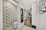 Step into a stylish and functional space featuring a chic powder room with whimsical tree-patterned wallpaper.