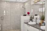 Experience luxury in this modern bathroom featuring a spacious walk-in shower with elegant marble-look tiles and a rainfall showerhead.