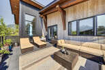 Experience outdoor living at its finest on this spacious patio, featuring comfortable lounge chairs and a sectional sofa perfect for entertaining.
