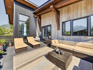 Experience outdoor living at its finest on this spacious patio, featuring comfortable lounge chairs and a sectional sofa perfect for entertaining.