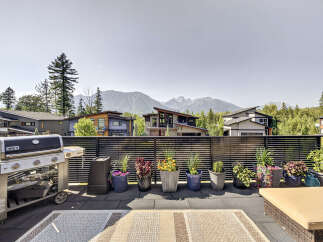 Enjoy breathtaking mountain views from this stunning modern home's expansive rooftop deck.