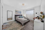 This inviting bedroom features a plush upholstered headboard and a comfortable bed adorned with decorative pillows and a cozy throw.