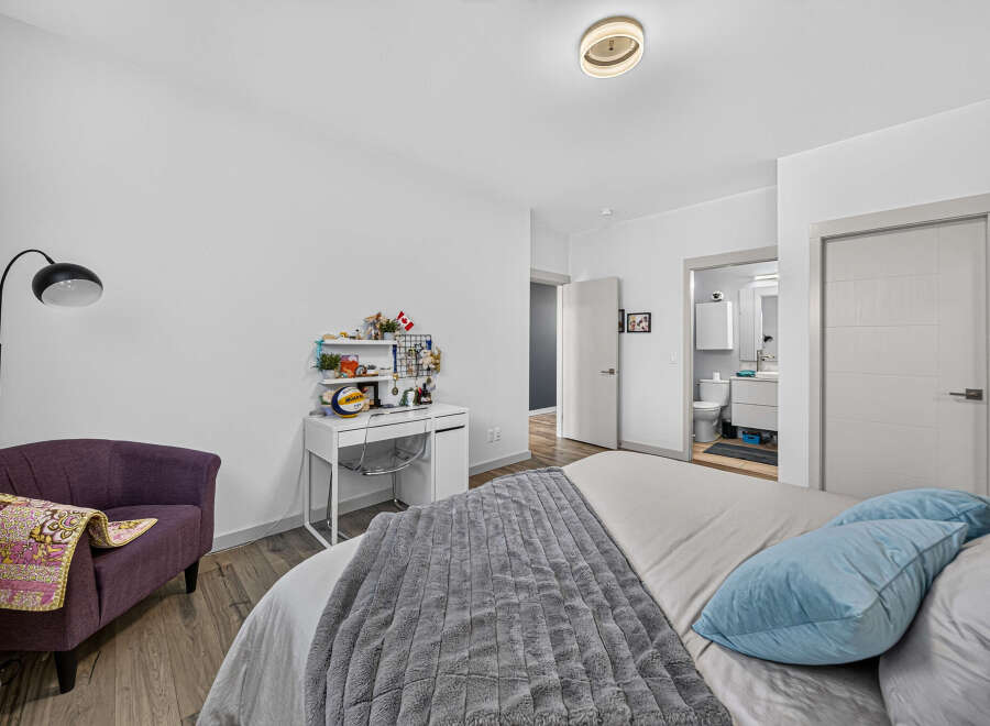 Discover this charming bedroom featuring a comfortable bed with plush blue pillows and a cozy grey throw blanket.
