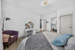 Discover this charming bedroom featuring a comfortable bed with plush blue pillows and a cozy grey throw blanket.