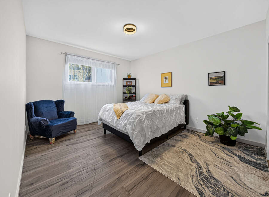 Discover this inviting bedroom featuring a plush navy armchair perfect for relaxation.