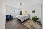 Discover this inviting bedroom featuring a plush navy armchair perfect for relaxation.