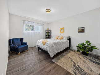 Discover this inviting bedroom featuring a plush navy armchair perfect for relaxation.