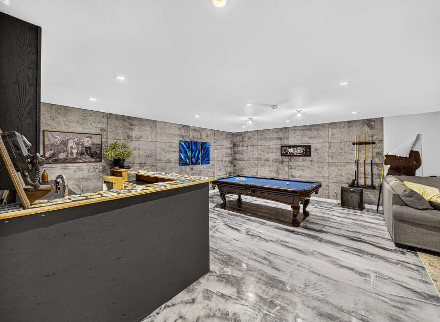Step into this ultimate entertainment space, featuring a stylish bar area with a vintage phone and a full-sized pool table perfect for friendly competitions.