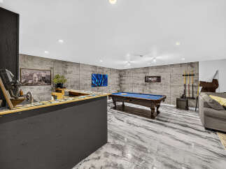 Step into this ultimate entertainment space, featuring a stylish bar area with a vintage phone and a full-sized pool table perfect for friendly competitions.
