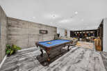 Experience ultimate entertainment in this modern basement featuring a professional pool table and a dedicated music area with guitars and a drum set.