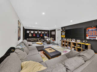 This entertainment room is a music lover's paradise, featuring a collection of guitars displayed on the wall and a full drum set ready for action.