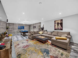 Experience ultimate relaxation in this modern basement living area, featuring a spacious sectional sofa perfect for gatherings.