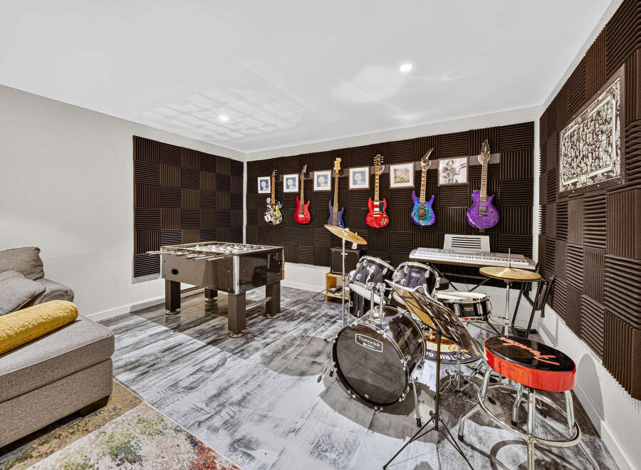 Unleash your inner rockstar in this ultimate entertainment room, complete with a foosball table and a fully equipped drum set.
