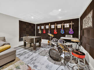 Unleash your inner rockstar in this ultimate entertainment room, complete with a foosball table and a fully equipped drum set.