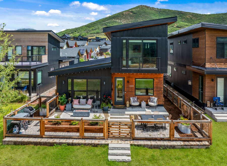 Experience modern mountain living in this stunning contemporary home, featuring a sleek design with wood and dark metal accents.