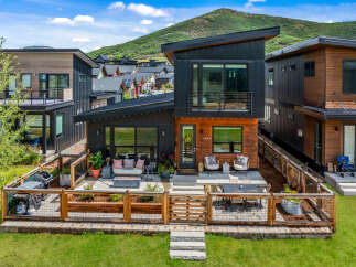 Experience modern mountain living in this stunning contemporary home, featuring a sleek design with wood and dark metal accents.