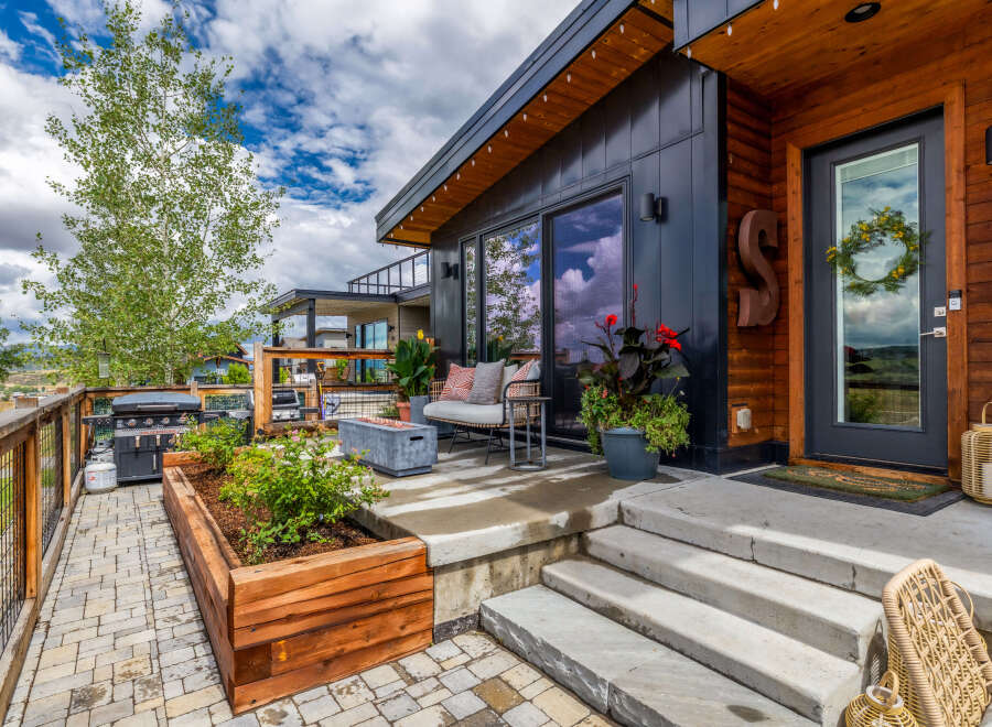 Experience modern mountain living with this stunning property featuring a sleek dark exterior and warm wood accents.