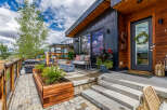 Experience modern mountain living with this stunning property featuring a sleek dark exterior and warm wood accents.