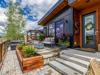 Experience modern mountain living with this stunning property featuring a sleek dark exterior and warm wood accents.