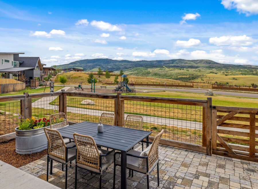 Enjoy outdoor living with this spacious patio featuring a dining set and a beautiful planter box.